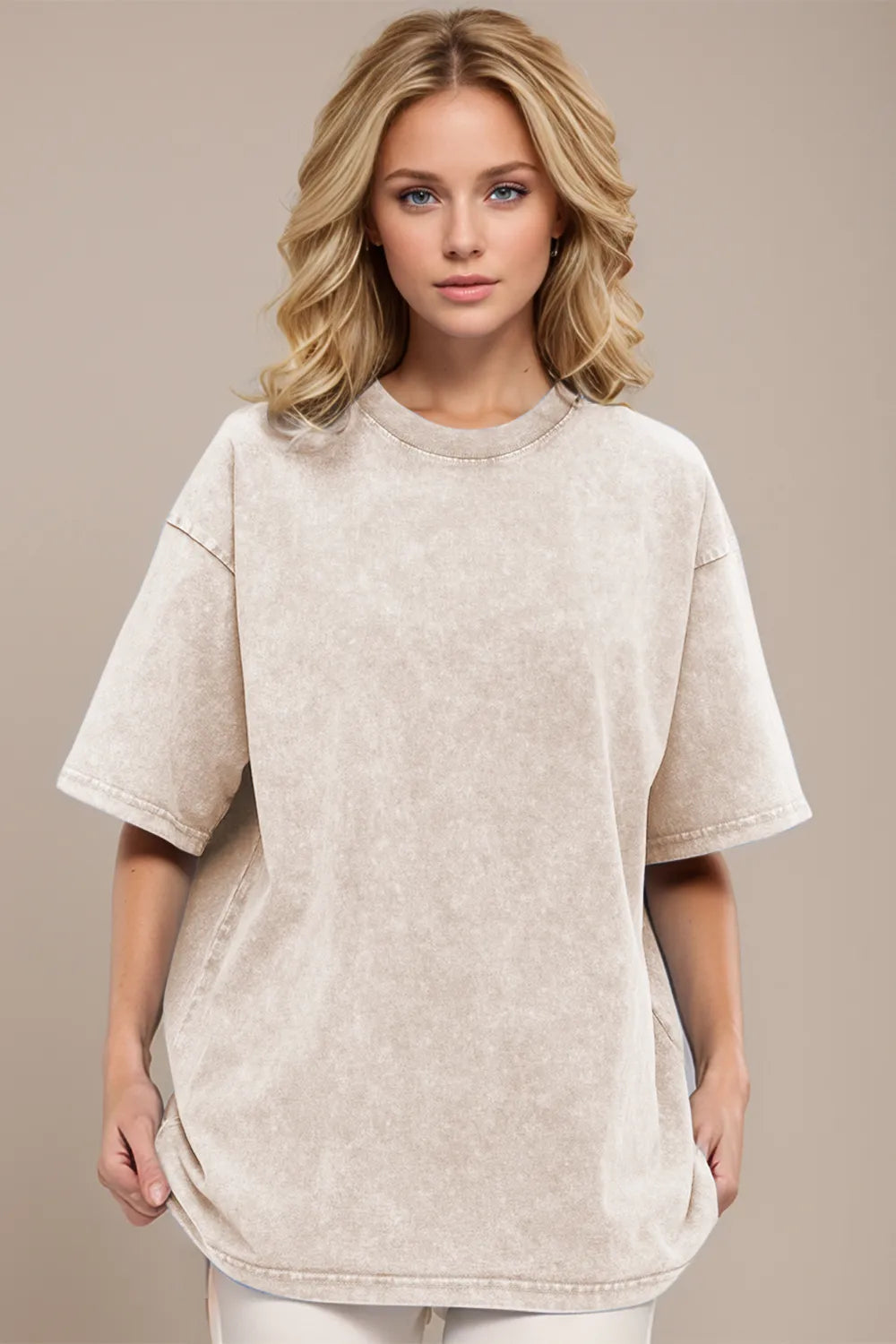 Woman wearing a beige oversized t-shirt against a neutral background