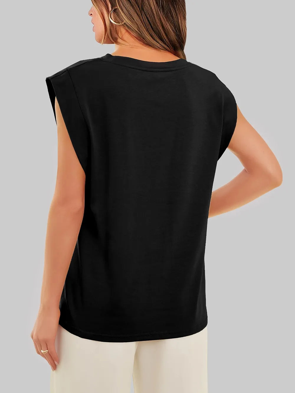 Person wearing a black sleeveless top on a gray background