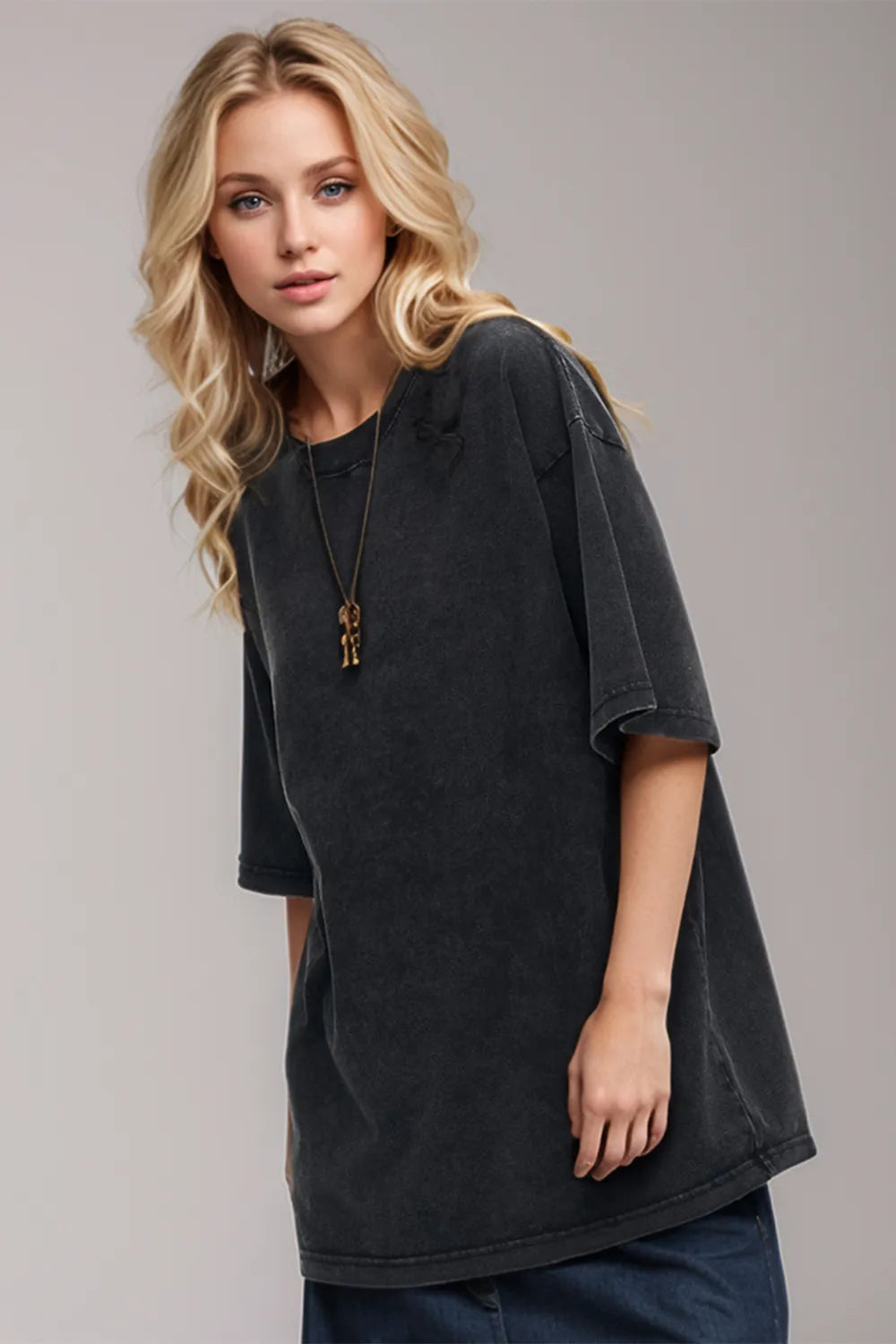Woman wearing a black oversized t-shirt against a plain background