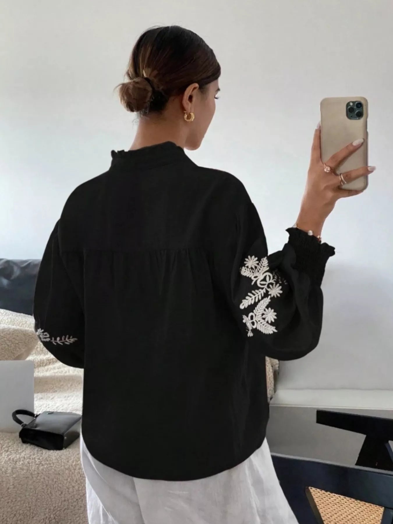 Black embroidered blouse angled profile featuring elegant button front and embroidery details