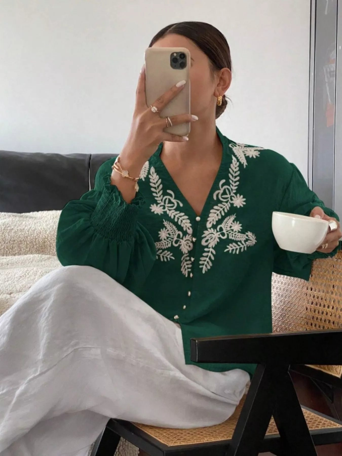 Green embroidered blouse close up showing decorative embroidery and premium finish