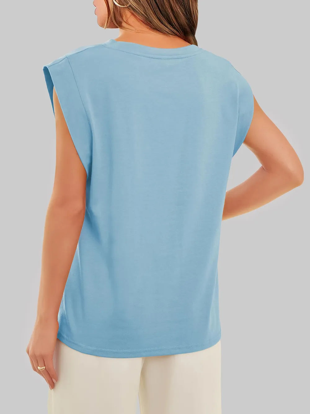 Light blue sleeveless top worn by a person on a gray background