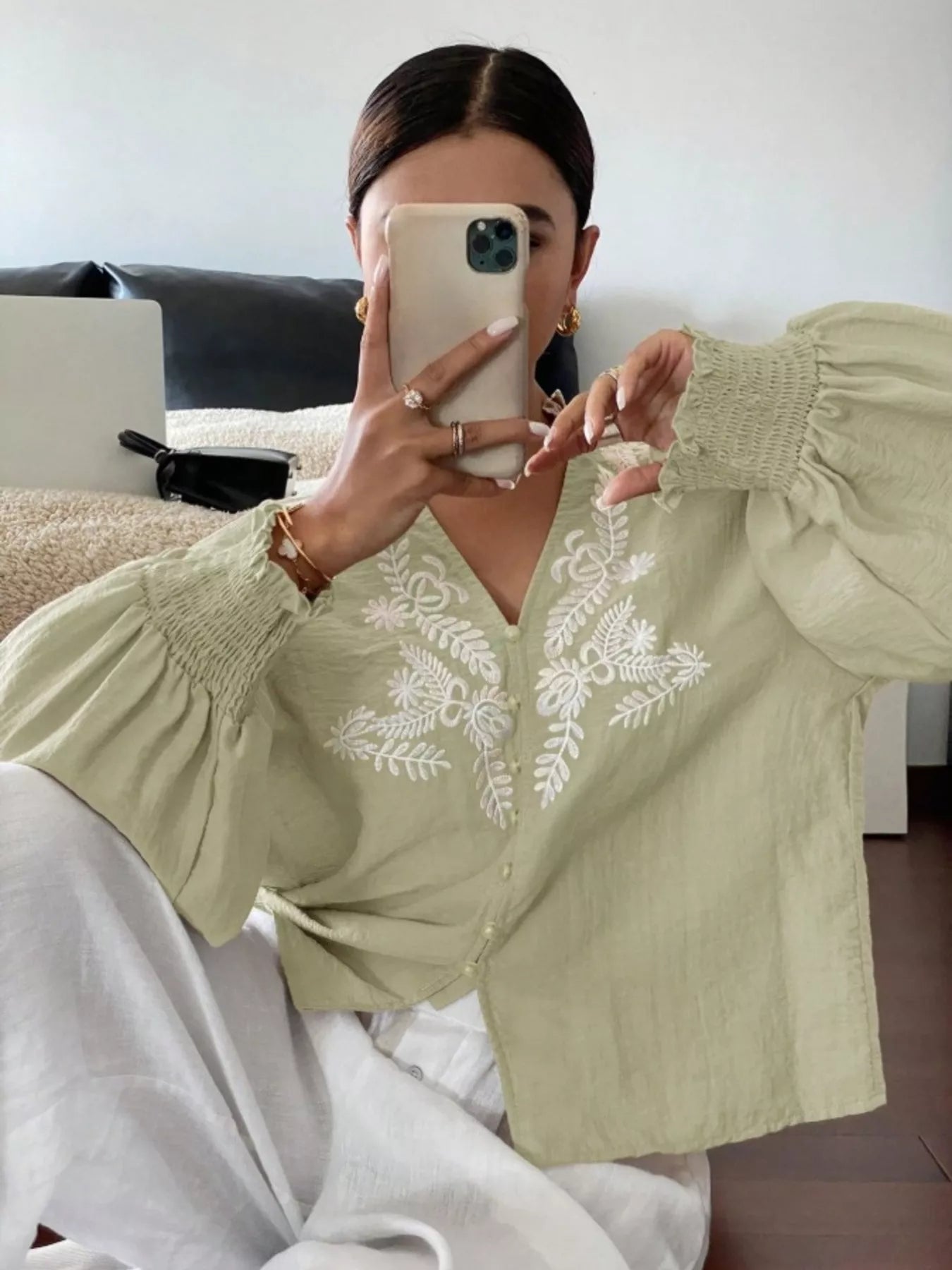 Light green embroidered button front blouse close up highlighting craftsmanship and texture
