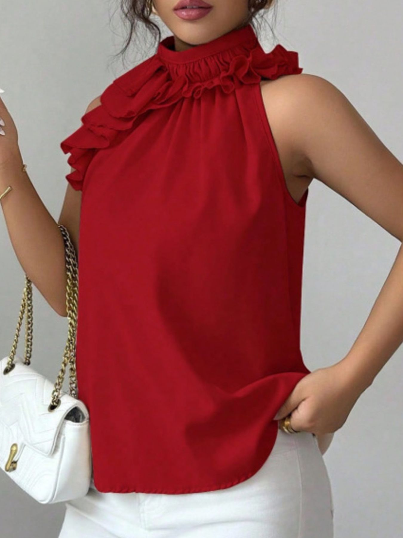 Red sleeveless fashion top with ruffled high neck and decorative button placket for smart casual styling