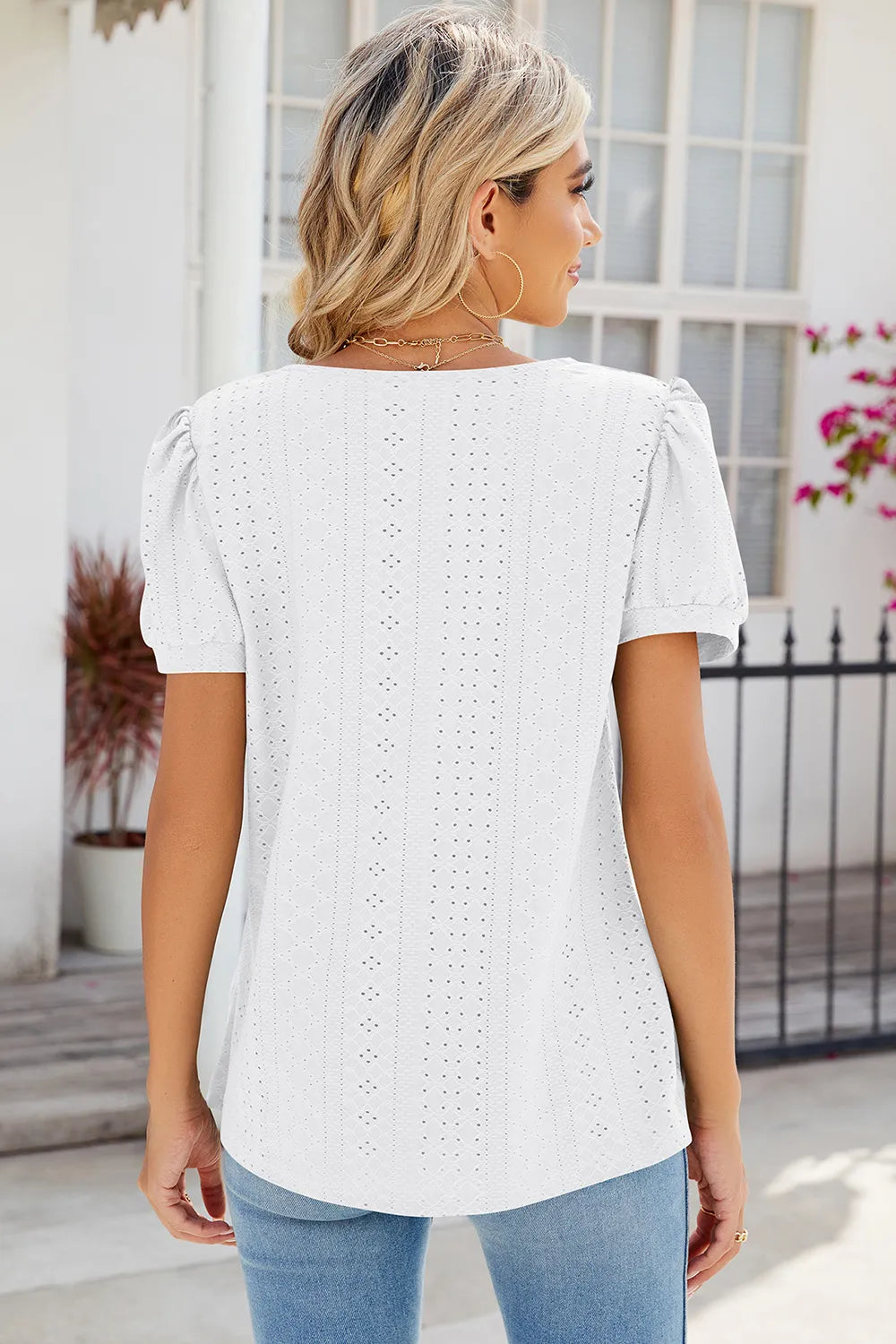 White broderie anglaise fashion top with decorative eyelet pattern and relaxed fit