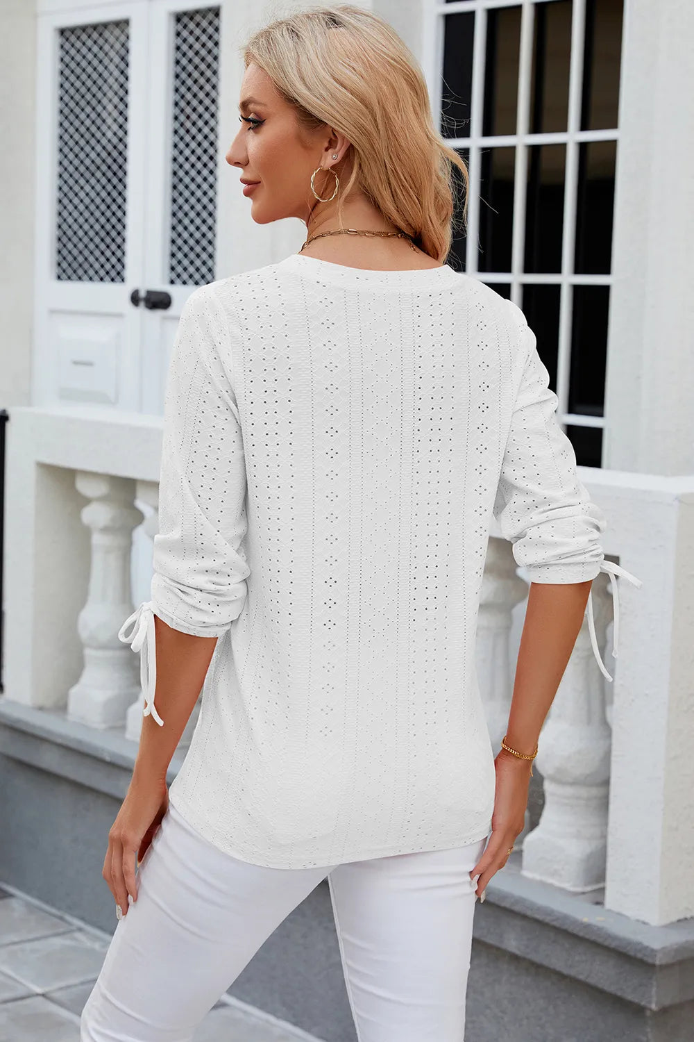 White broderie anglaise top with embroidered eyelet pattern and feminine silhouette