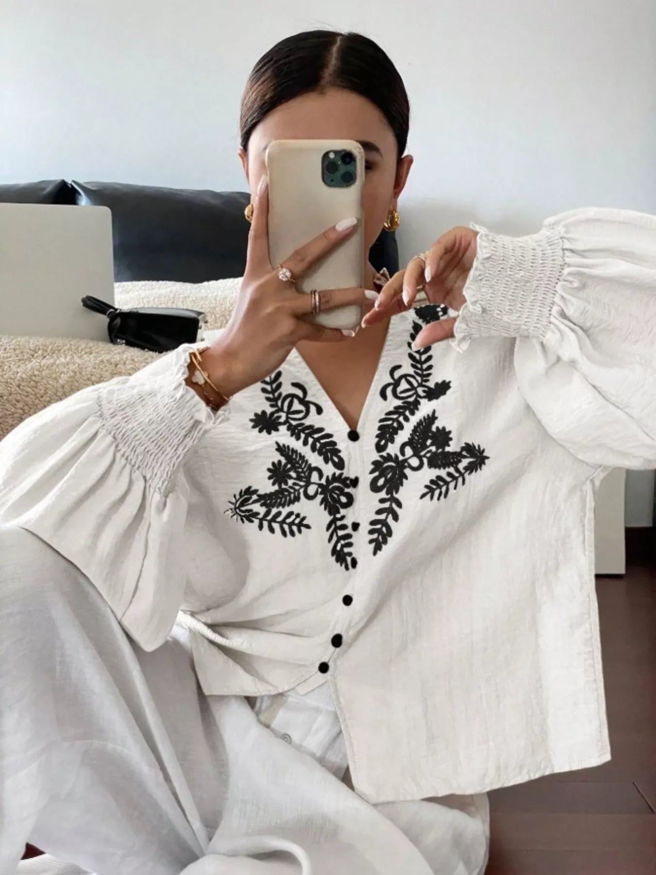 White embroidered button front blouse close up highlighting intricate embroidered accents