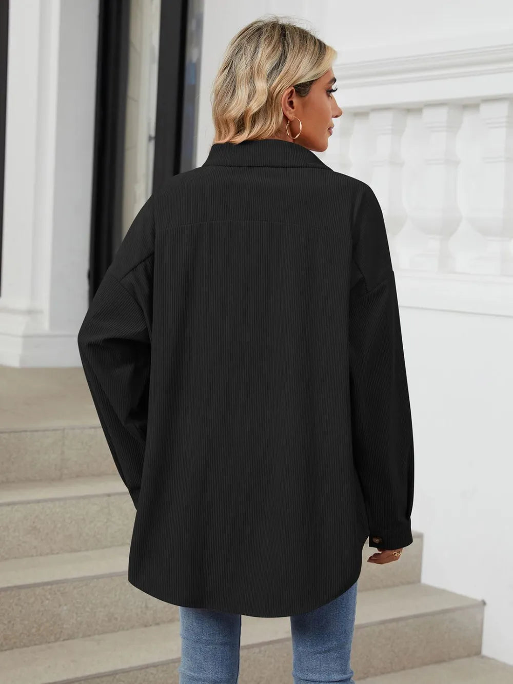 Back view of black dropped shoulder collared long sleeve shirt with loose oversized fit