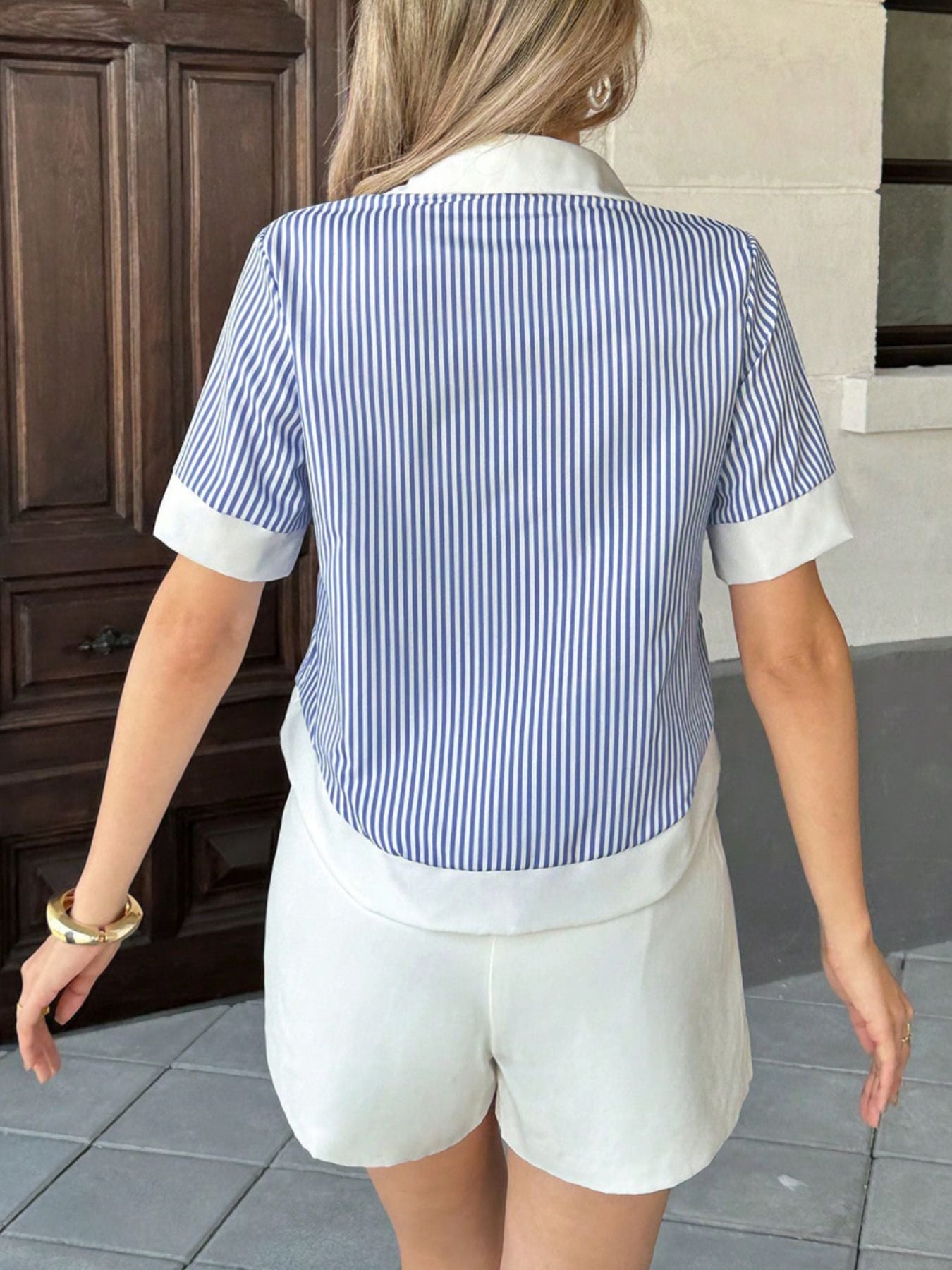 Back view of blue striped short sleeve button down shirt with vertical stripe pattern
