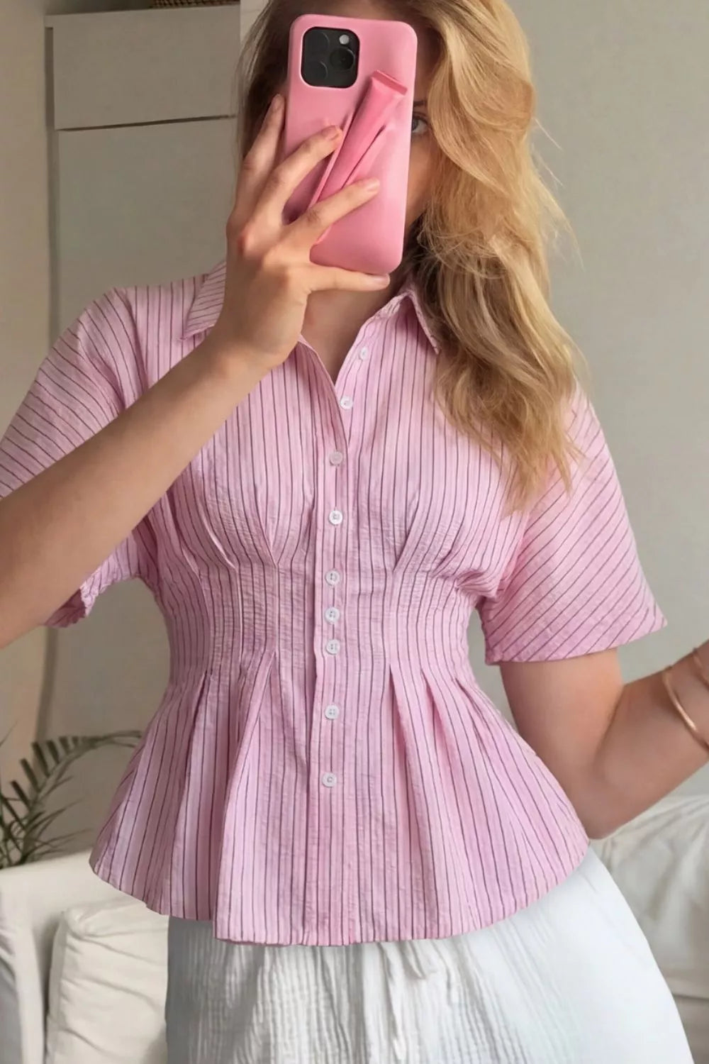 Blush pink striped peplum button up shirt styled casually with light wash trousers and fitted silhouette