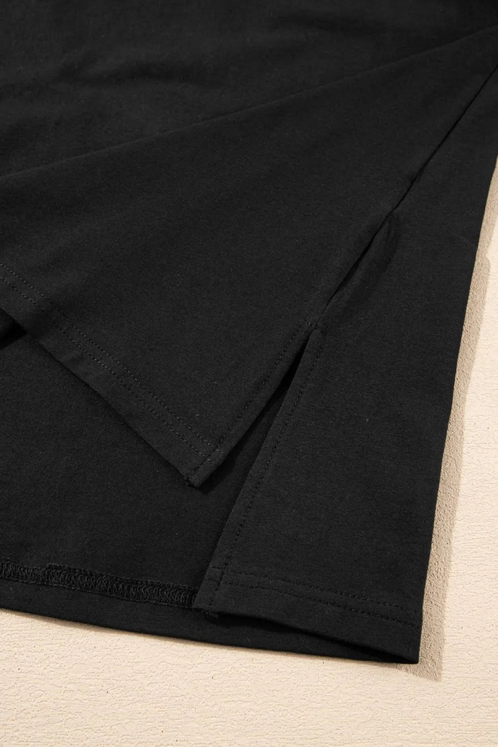 Close-up of black fabric on a beige surface