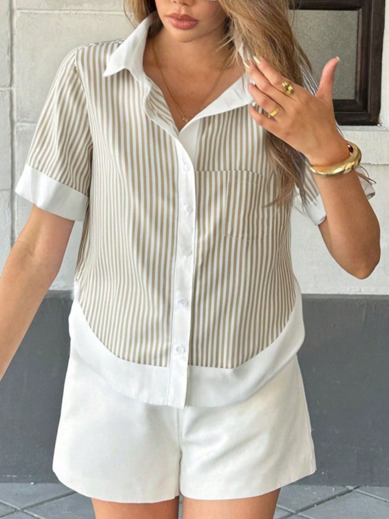 Khaki striped short sleeve button down shirt paired with tote bag and white shorts