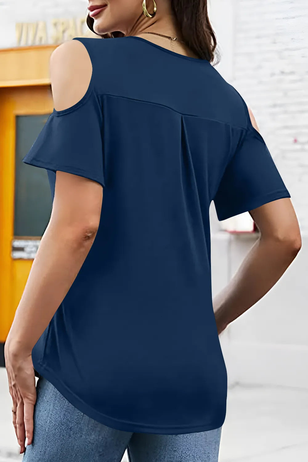 Navy blue cold-shoulder top worn by a person indoors.