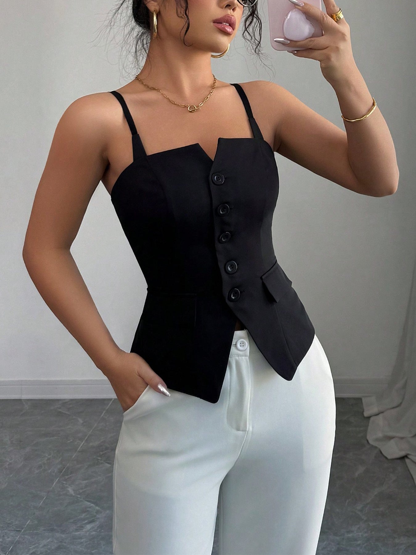 Women's black spaghetti strap cami top with button-front detailing and a structured waist, three-quarter view.