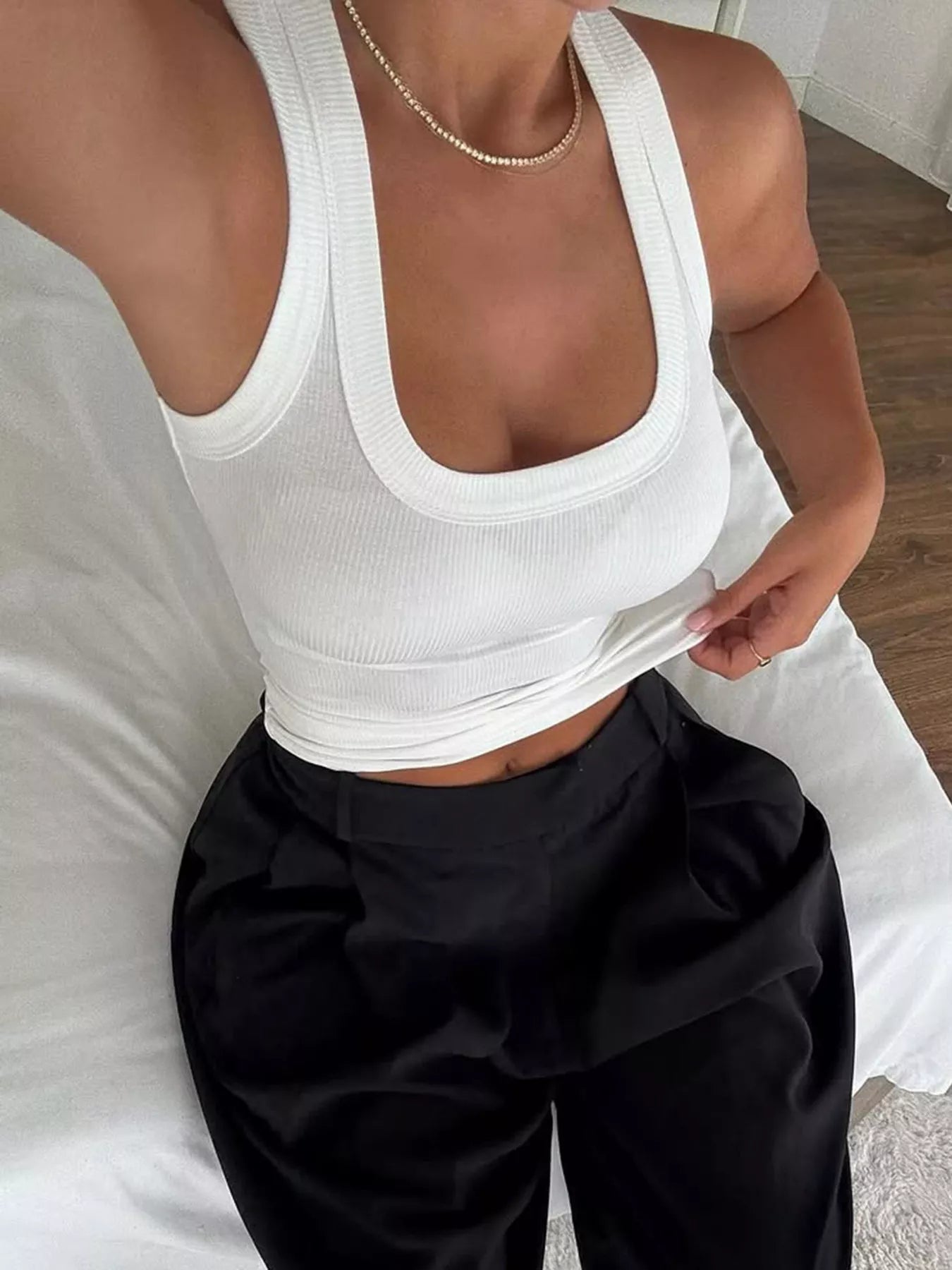 White ribbed halter tank top paired with black high-waisted trousers for a chic summer outfit