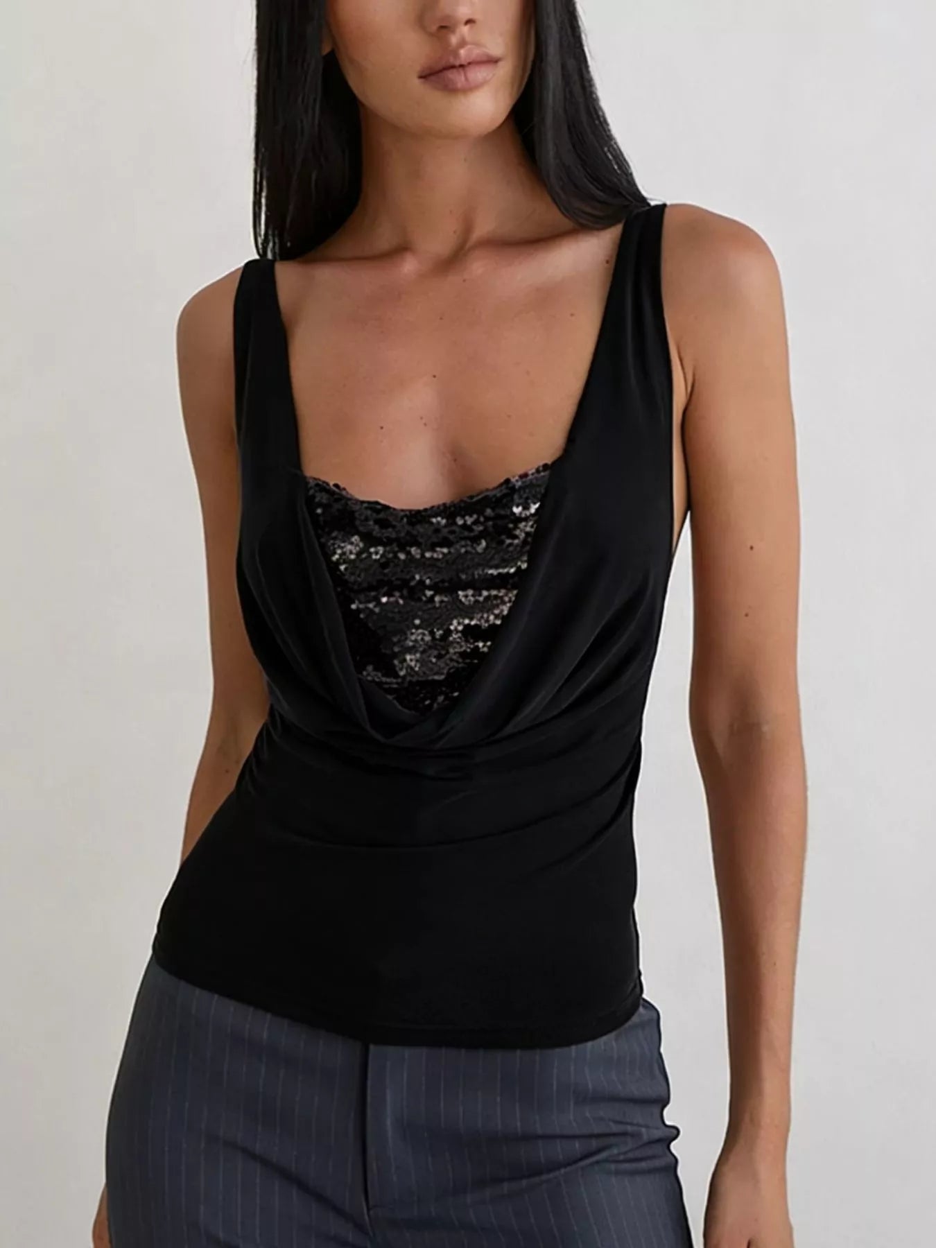 Women's black fitted cami top featuring a draped cowl neckline with lace panel detail, styled with grey trousers in a smart casual look