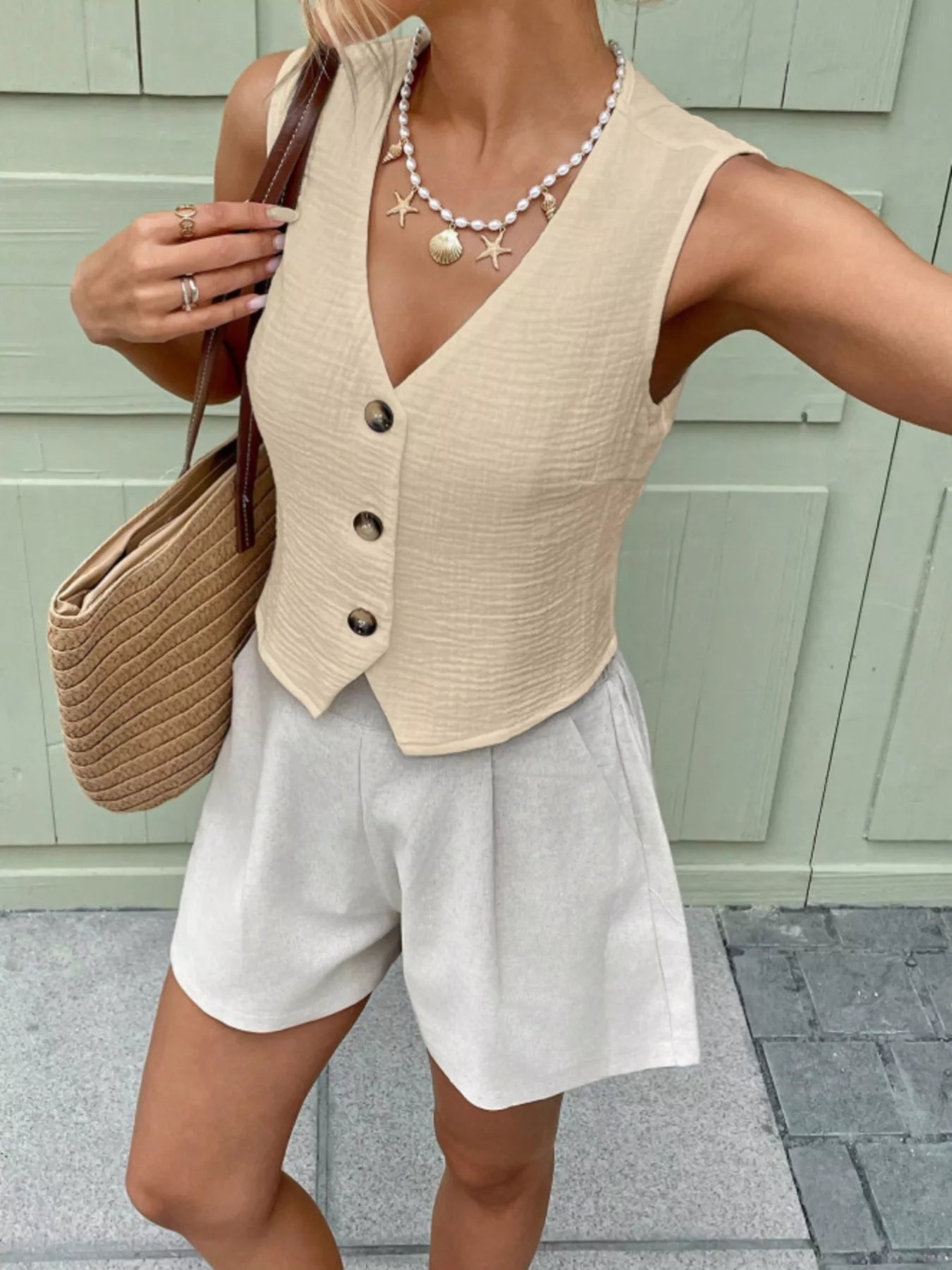 Side profile of an apricot sleeveless cotton vest top with a tailored fit and textured fabric