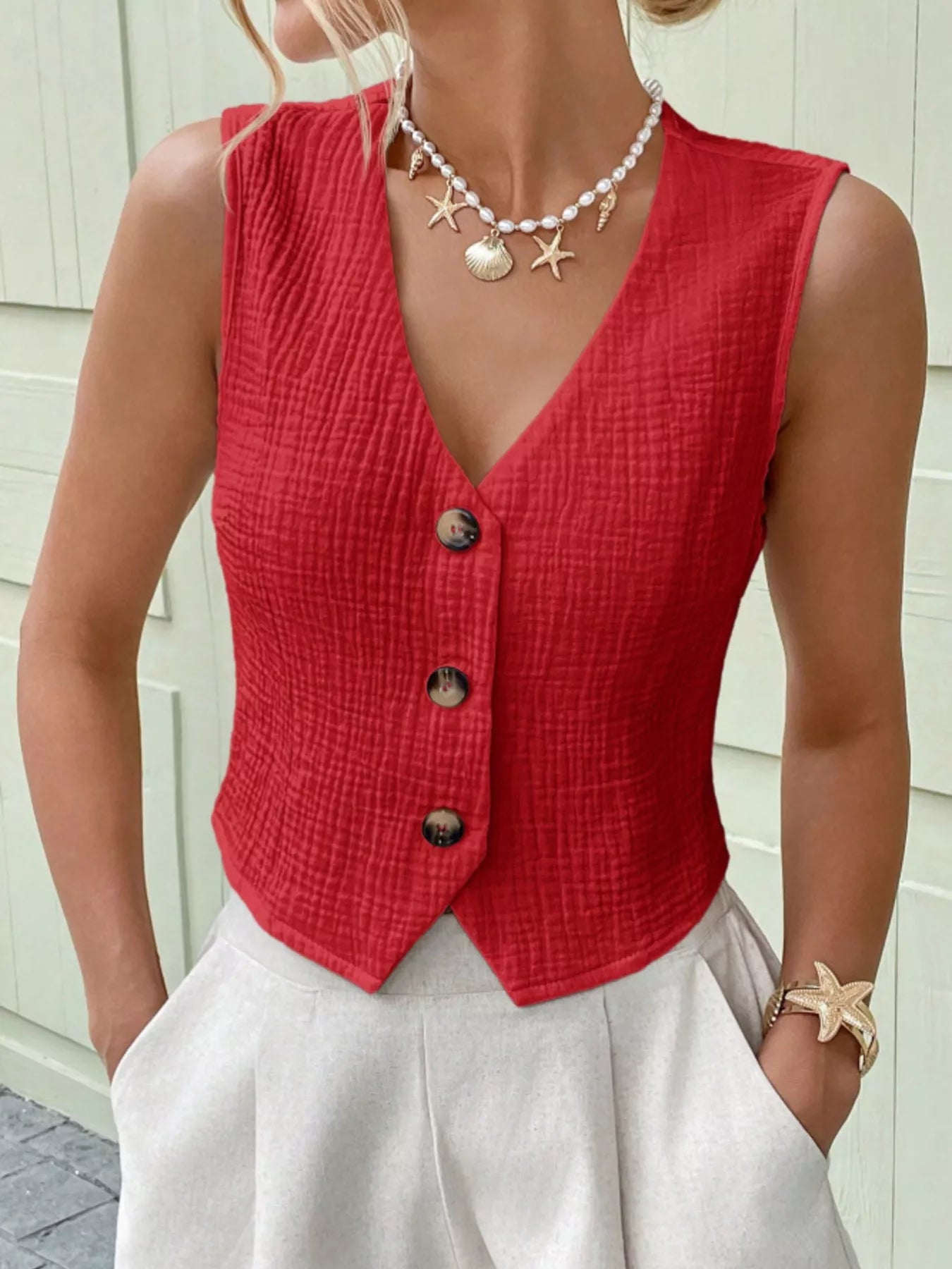 Close-up of the textured fabric and button-front design on a red cotton vest top